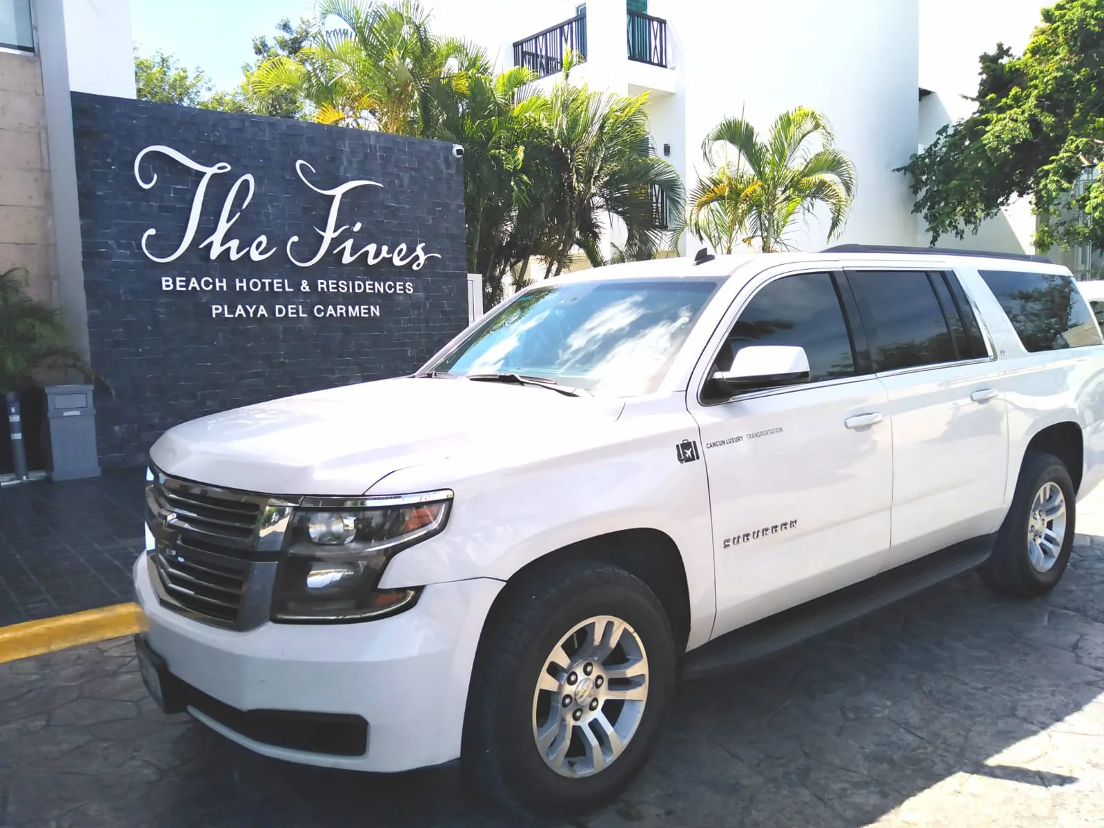 White luxury SUV parked in front of The Fives Hotel Playa del Carmen 
