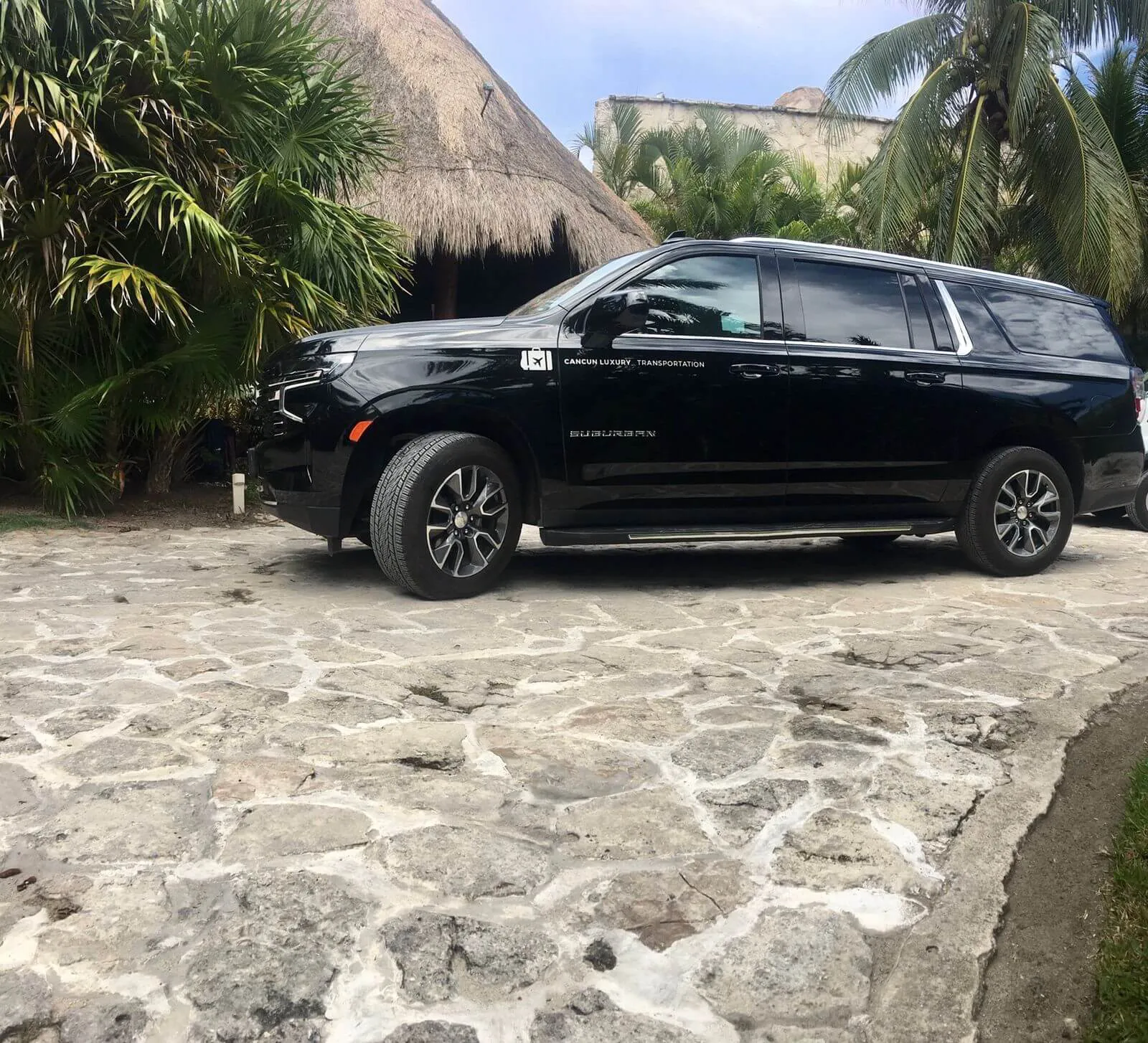 Luxury black Suburban 2021 parked in front of a palapa