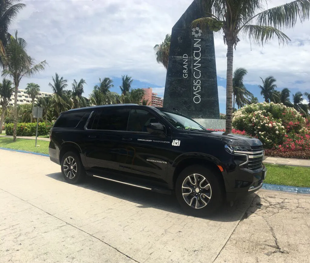 Black luxury SUV in front of Grand Oasis Cancun obelisc