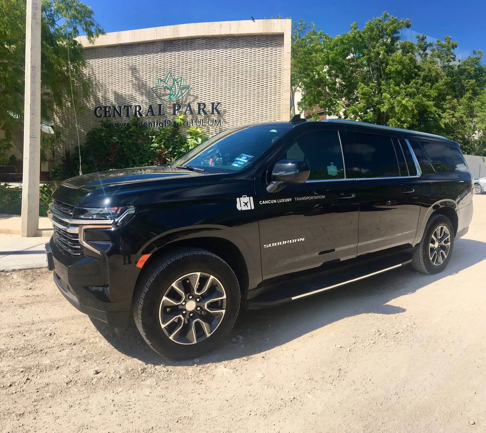 Black Surbuban 2021 parked in front of Central Park Tulum sign 