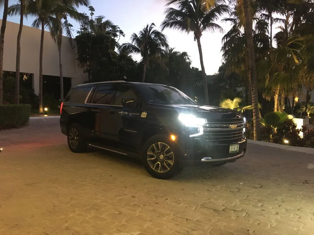 Black SUV with lights on during sunset